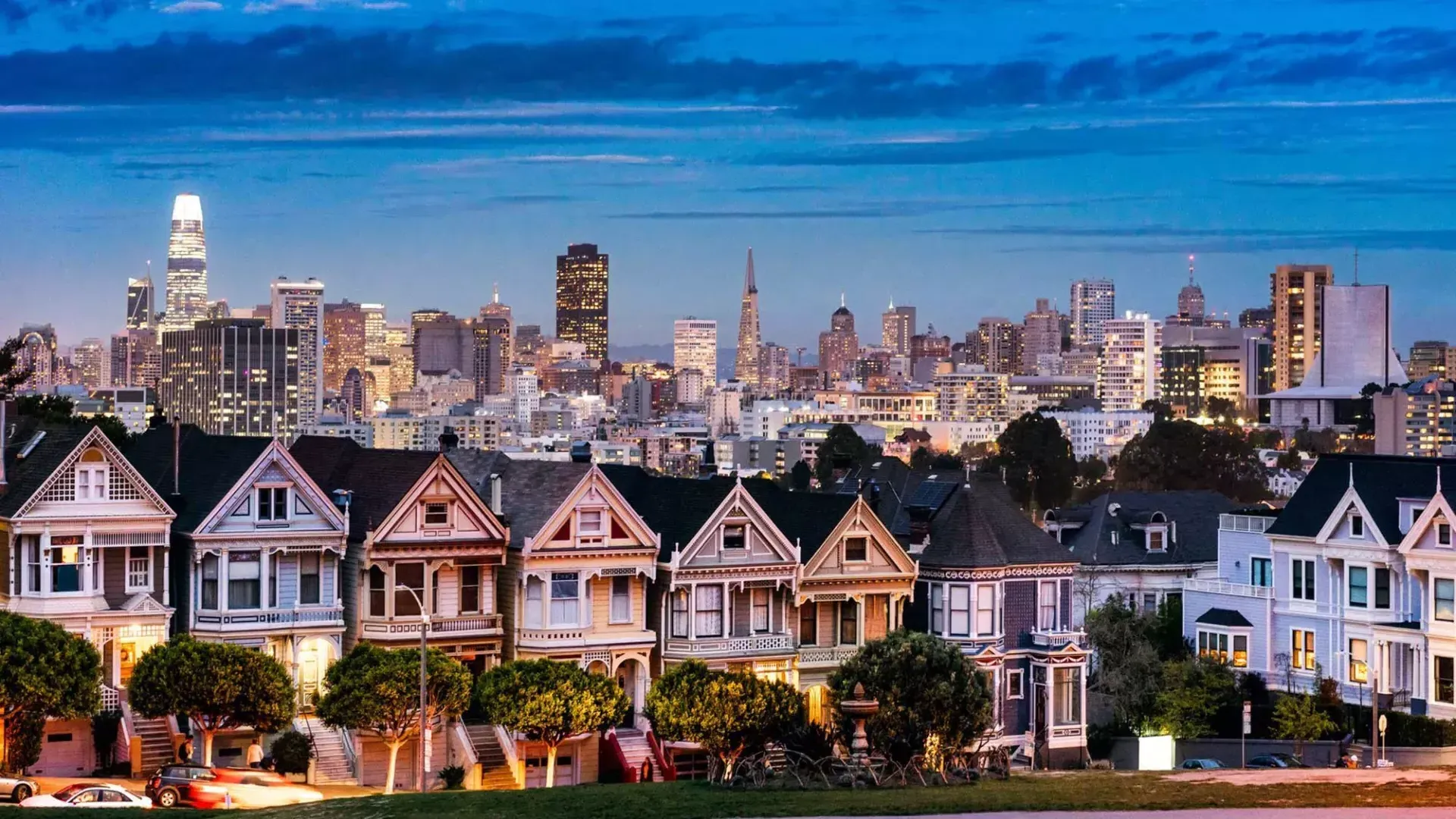 阿拉莫广场(Alamo Square)著名的彩绘女士们站在贝博体彩app日落时分的天际线前。.